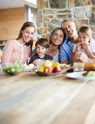 Buy stock photo A portrait of a happy multi-generational family sitting at a table and having lunch together