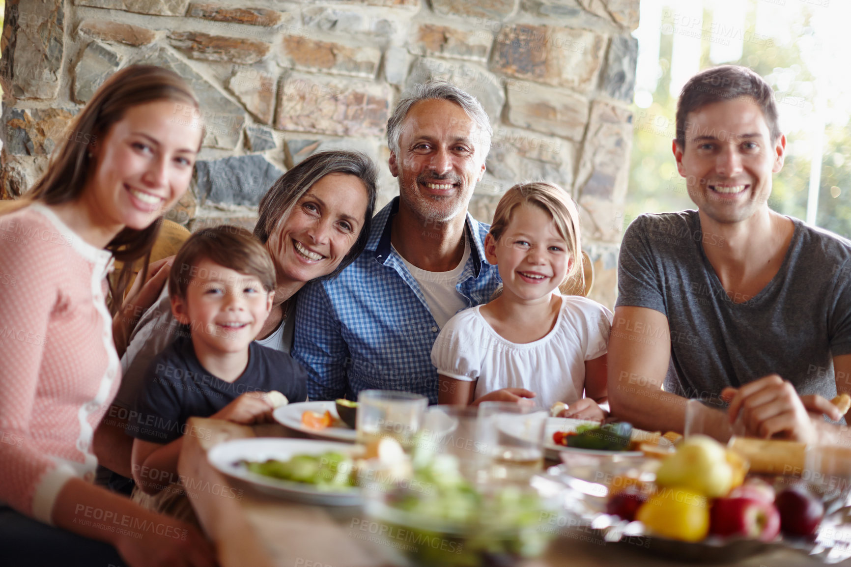Buy stock photo A portrait of a happy multi-generational family having a meal together outdoors