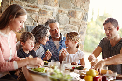 Buy stock photo A happy multi-generational family eating lunch together outdoors