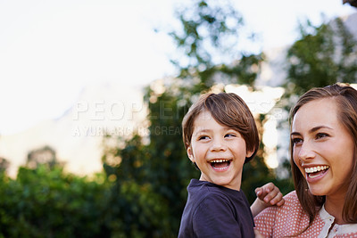 Buy stock photo Shot of a young mother holding her happy son outside in the garden