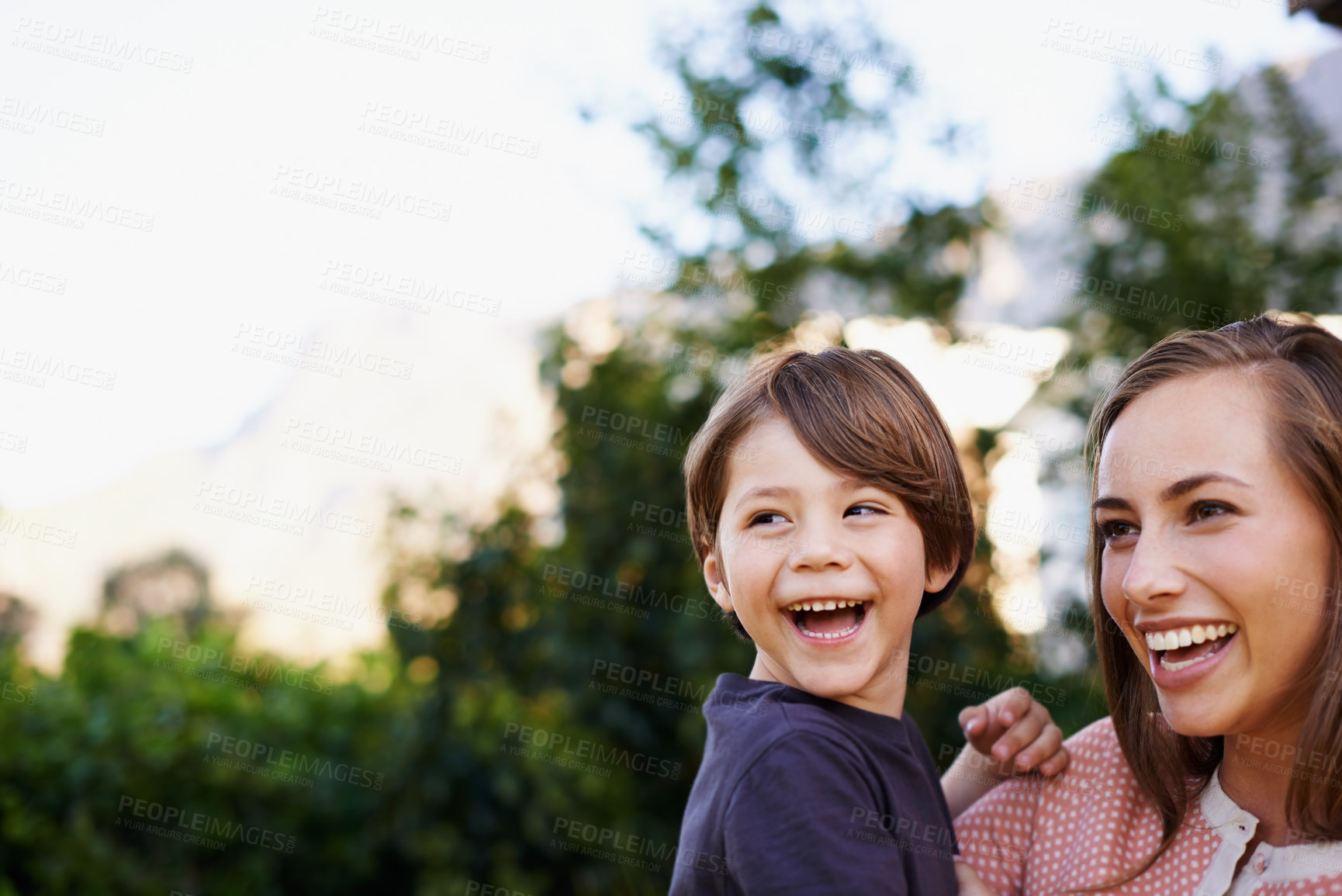 Buy stock photo Shot of a young mother holding her happy son outside in the garden