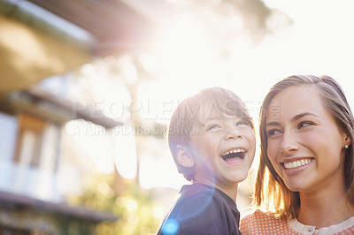 Buy stock photo Shot of a young mother holding her happy son outside