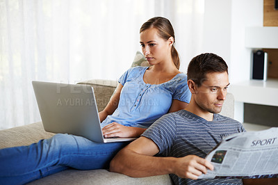 Buy stock photo Couple, home and relax or news on laptop, reading and bonding together in silence on couch. People, newspaper and woman browse on internet or website, man and article for information and marriage
