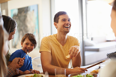 Buy stock photo Family, together and eating food in house for nutrition with dining table, talking and tableware. Young boy, happy people and hosting for lunch with conversation, salad and smile in home for laughing