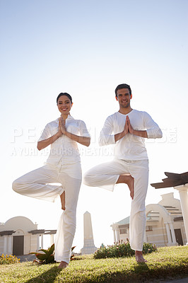 Buy stock photo Full length shot of a young couple doing yoga outdoors