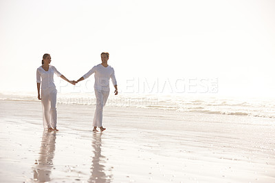 Buy stock photo Couple, sea and holding hands while walking on beach, travel and commitment with trust and bonding outdoor. Love, care and support in relationship, honeymoon or anniversary with peace in nature