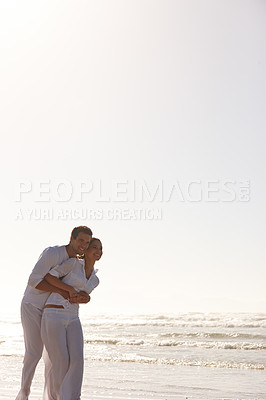 Buy stock photo Happy couple, hug and beach with romance for love, embrace or valentines day in outdoor nature. Man and woman enjoying holiday, weekend or getaway together by the ocean coast or sea on mockup space