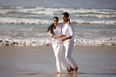 Buy stock photo Happy couple, hug and walking on beach for love, embrace or valentines day in outdoor nature. Man and woman enjoying holiday, weekend or getaway together for bonding or romance by the ocean coast