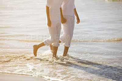 Buy stock photo Walking, beach and legs of couple in water for summer holiday, vacation and weekend by ocean. Travel, sunset and feet of man and woman holding hands in waves for bonding, relax and relationship