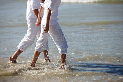 Buy stock photo Walking, beach and legs of couple holding hands for summer holiday, vacation and weekend by ocean. Travel, sunset and feet of man and woman in waves, water and sea for bonding, relax and relationship