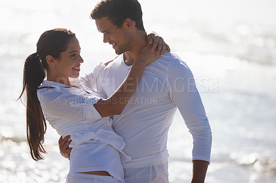 Buy stock photo Cropped shot of a young couple embracing at the beach