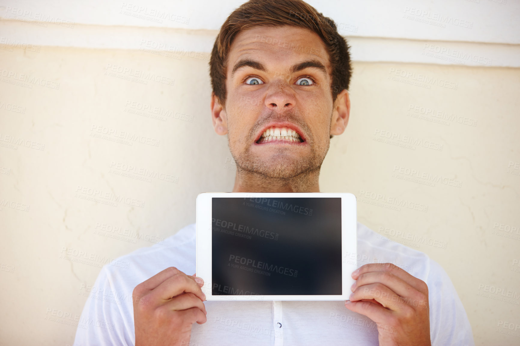 Buy stock photo Angry, portrait and man with tablet screen, mockup or presentation in a city with feedback on wall background. Digital, display or frustrated male person in outdoor with app review for travel problem