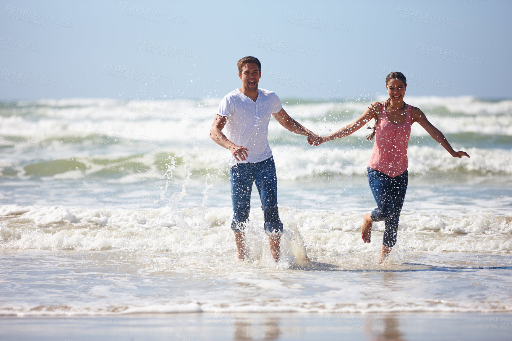 Buy stock photo Shot of a young couple being playful on the beach