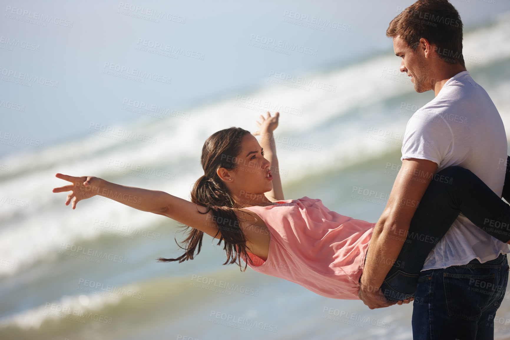 Buy stock photo Happy couple, carrying and flying on beach with love for support, care or fun on holiday, weekend or outdoor vacation. Playful man and woman with smile, relationship or summer bonding by ocean coast