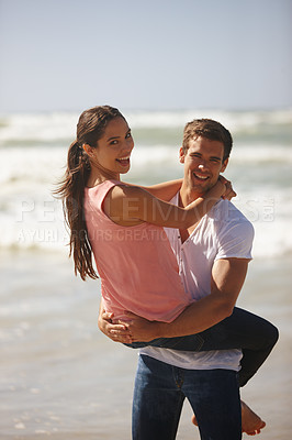 Buy stock photo Shot of a young couple being playful on the beach