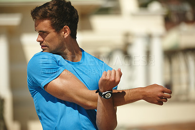 Buy stock photo Cropped shot of a young man stretching outside