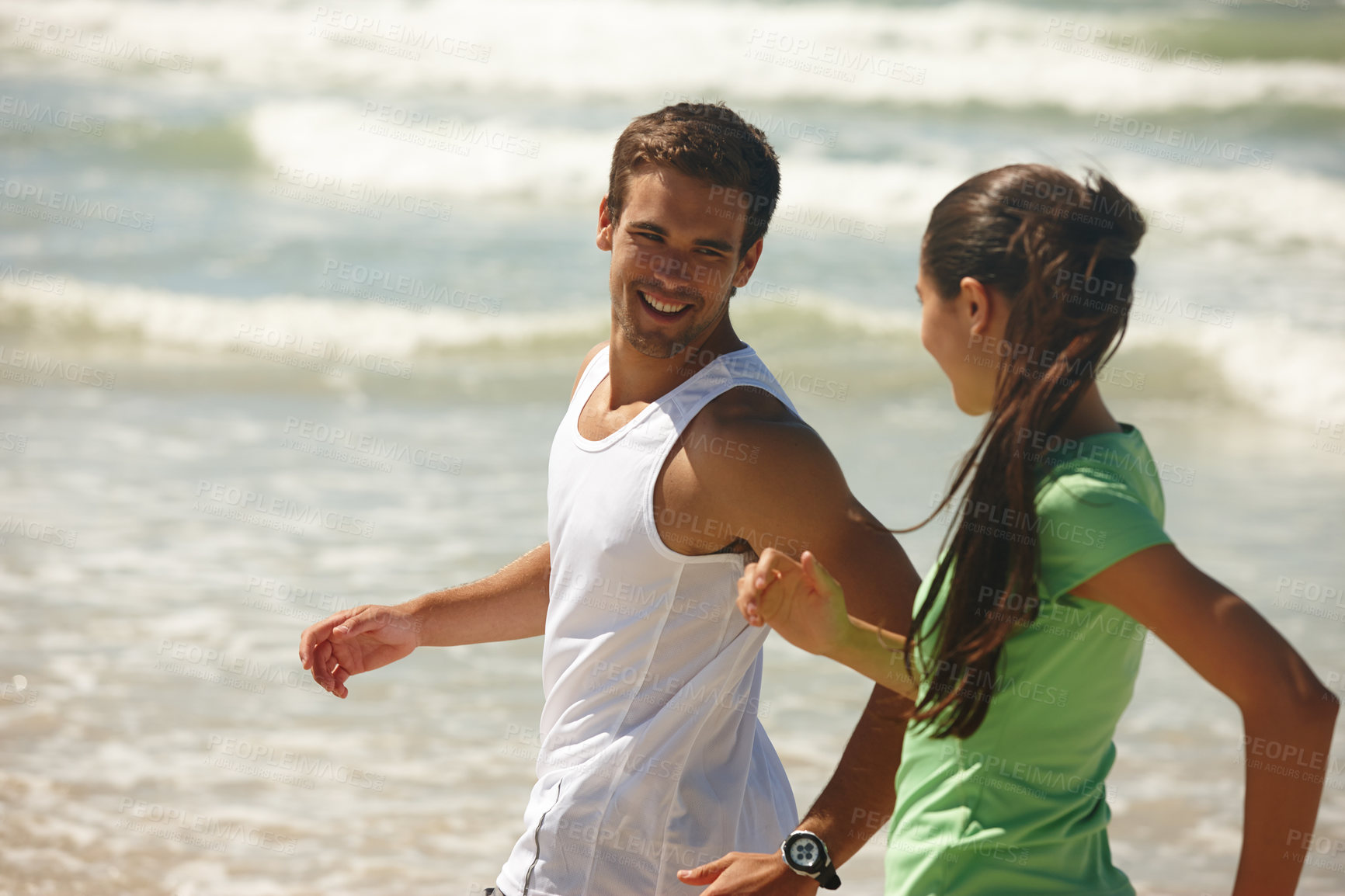 Buy stock photo Shot of a young couple jogging together on the beach