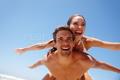 Buy stock photo Couple, piggyback and freedom on beach with happiness for bonding, summer vacation and travel adventure. Man, woman and love by ocean with mockup space for getaway, healthy relationship and blue sky