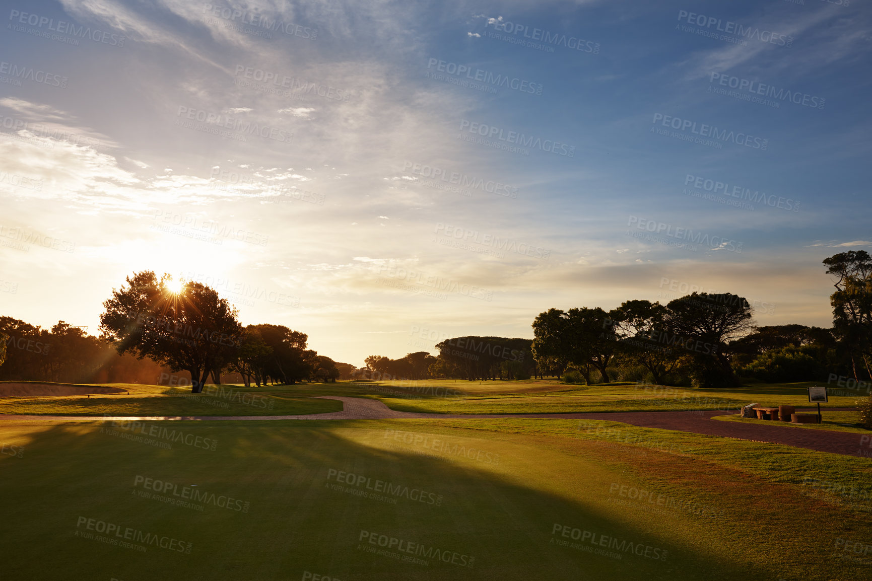 Buy stock photo Grass, sunset sky and trees on golf course with clouds, shadow and natural landscape with path in park. Nature, green and field with forest with sustainable environment, evening sunshine and woods