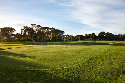 Buy stock photo Grass, blue sky and trees on golf course with forest, clouds and natural landscape for summer in park. Nature, green and field in woods at sports club with sustainable environment, sunshine and peace