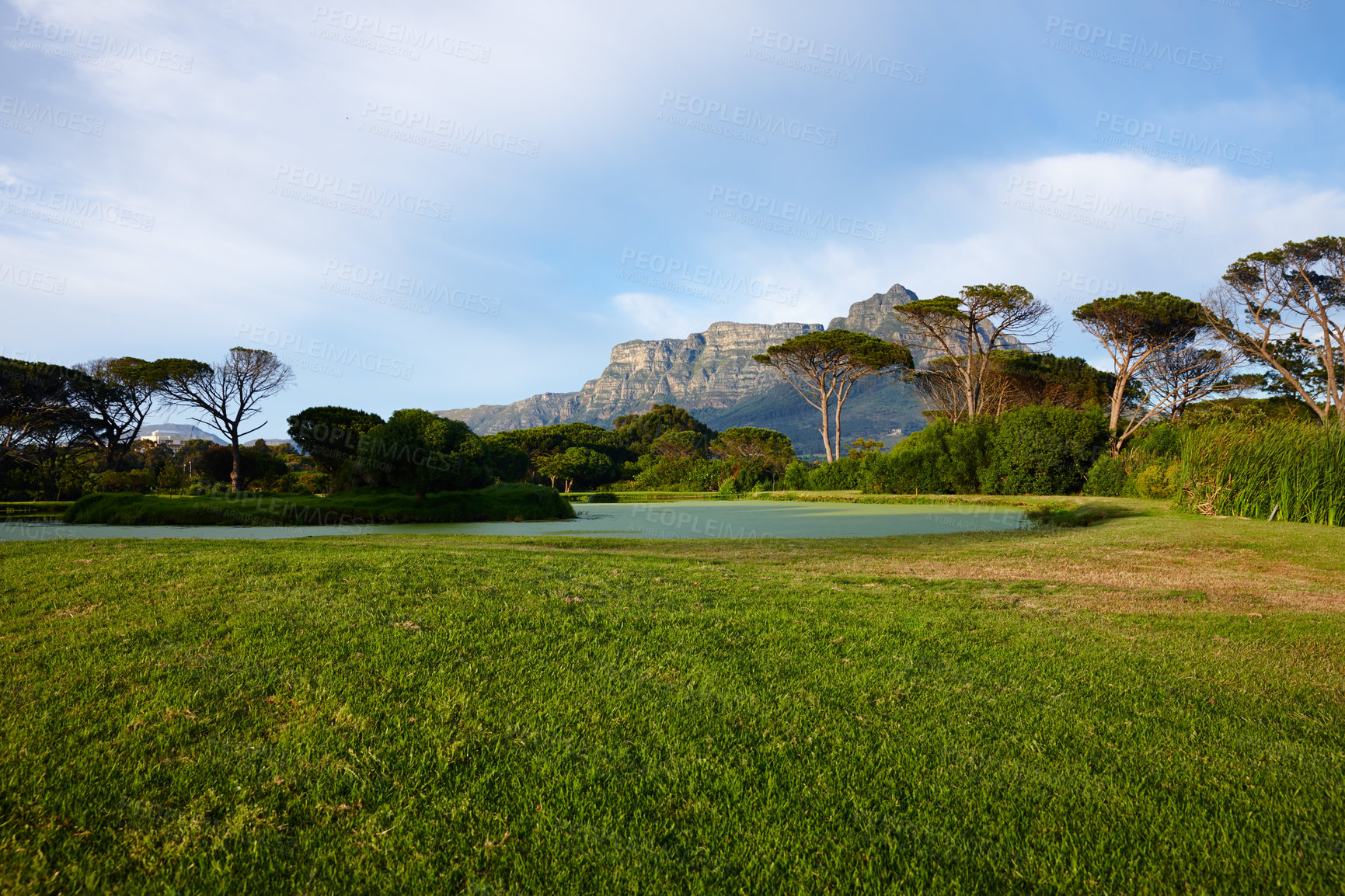 Buy stock photo Grass, sky and trees on golf course with mountain, lake and natural landscape water in park. Nature, green and field with forest with river, sustainable environment or summer sunshine in Canada.