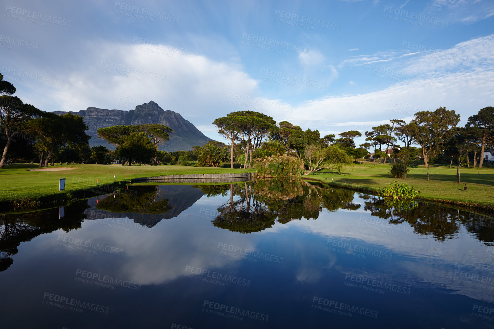 Buy stock photo Grass, lake and trees on golf course with mountain, clouds and natural landscape with river in park. Nature, green and field with sustainable environment, sunshine and blue sky reflection in Canada