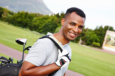 Buy stock photo Portrait of a handsome young man standing on a golf course with his bag of clubs