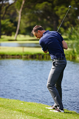 Buy stock photo Man, swing and playing with golf club for point, score or par by lake or pond in outdoor nature. Male person, sports player or golfer hitting ball in competition, challenge or practice on grass field
