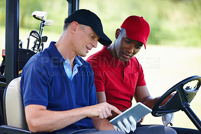 Buy stock photo Shot of two men in a golf cart looking at a digital tablet