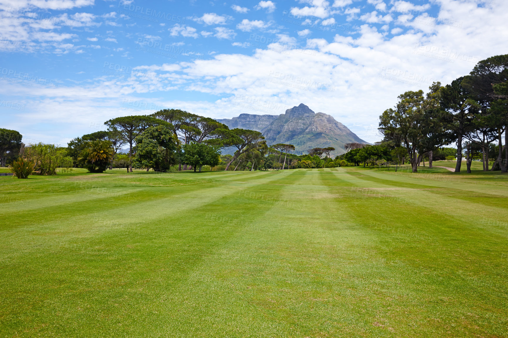 Buy stock photo Mountain, landscape and outdoor on grass at golf course in summer on holiday or vacation. Calm, morning and lawn with turf for sport in woods, forest or nature of park with trees and clouds on field