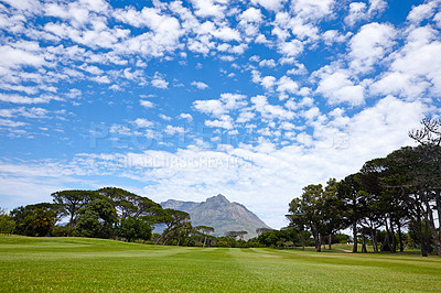 Buy stock photo Mountain, landscape and outdoor on grass at golf course in summer on holiday or vacation. Calm, morning and lawn with turf field for sport in woods, forest or nature of park with trees and clouds