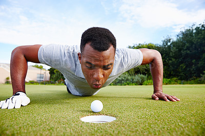 Buy stock photo Desperate golfer and cheating, blow ball in hole for victory on green field at competition. Serious man and closeup for challenge, sports fraud on target outdoors on grass or lawn at country club