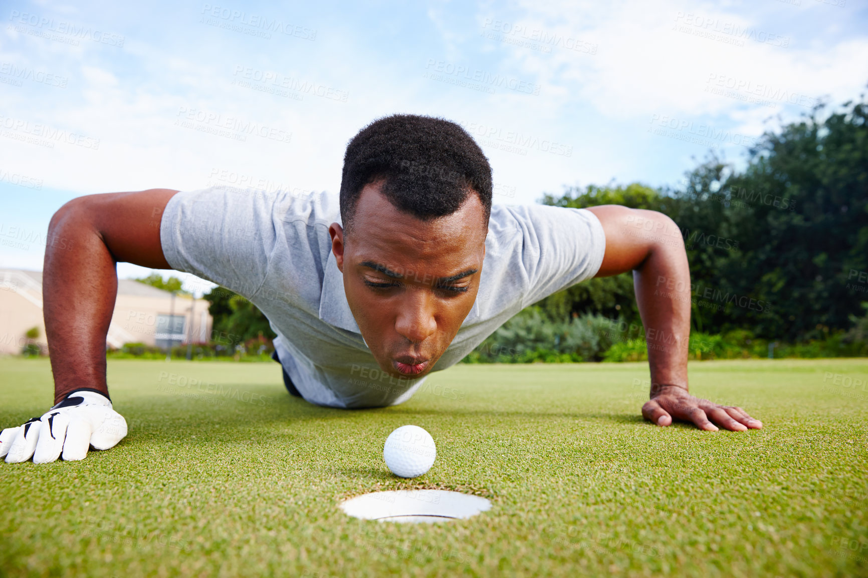 Buy stock photo Desperate golfer and cheating, blow ball in hole for victory on green field at competition. Serious man and closeup for challenge, sports fraud on target outdoors on grass or lawn at country club