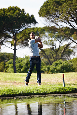 Buy stock photo Man, golfer and swing with club on grass field by the lake for point, score or par in outdoor nature. Male person or sports player hitting ball away on green lawn or golf course by water or pond