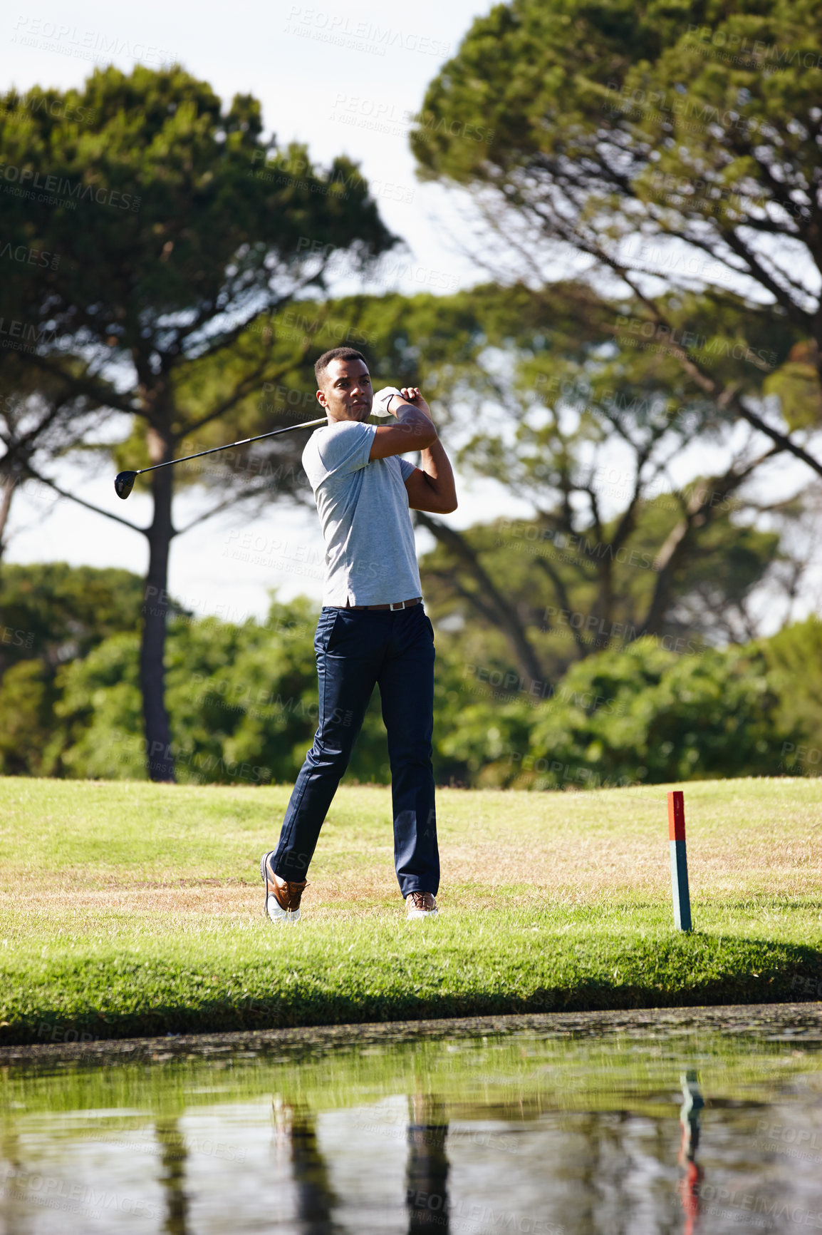 Buy stock photo Man, golfer and swing with club on grass field by the lake for point, score or par in outdoor nature. Male person or sports player hitting ball away on green lawn or golf course by water or pond