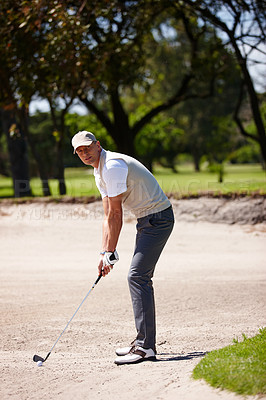 Buy stock photo Man, portrait and golfer with club for stroke, point or strike in sand pit by grass field in nature. Male person or sports player getting ready to swing ball in dirt for game or match on golf course