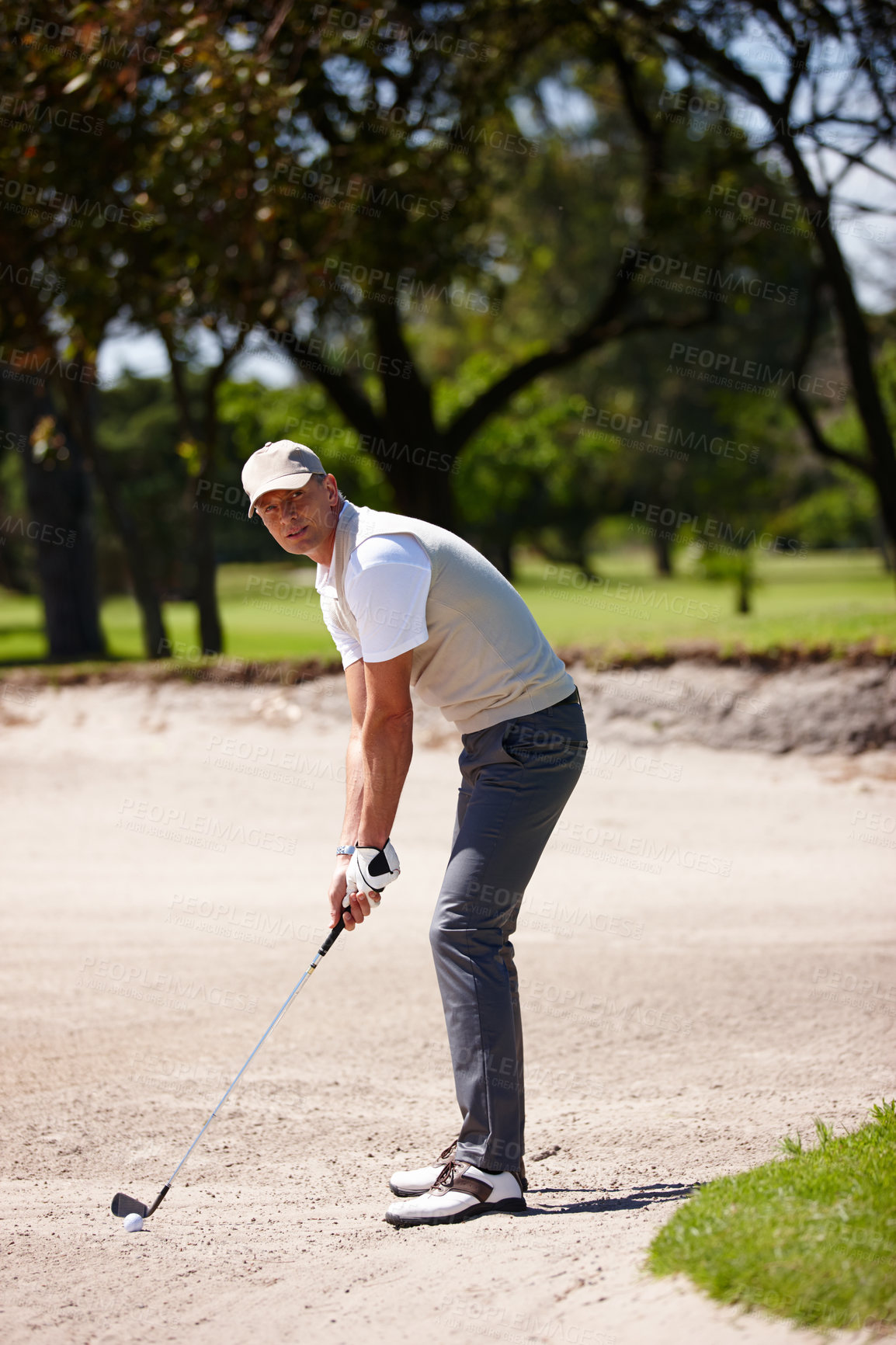 Buy stock photo Man, portrait and golfer with club for stroke, point or strike in sand pit by grass field in nature. Male person or sports player getting ready to swing ball in dirt for game or match on golf course