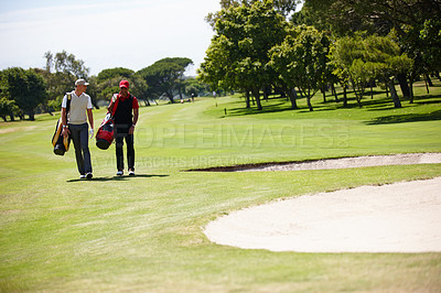 Buy stock photo Golf, sports and men walking with bag after practice or training on green lawn for partnership or collaboration. Friends, golfers and exercise for trust, fitness and community outdoor on field.