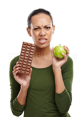 Buy stock photo Portrait, woman and choosing chocolate versus apple for health, wellness and diet benefits. Thinking, person and choice of candy, fruits and healthy food challenge for nutritional balance in studio