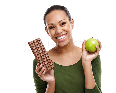 Buy stock photo Portrait, happy woman and chocolate versus apple for health, wellness and diet benefits. Smile, person and choice of candy, fruits and organic food challenge for nutritional balance in studio