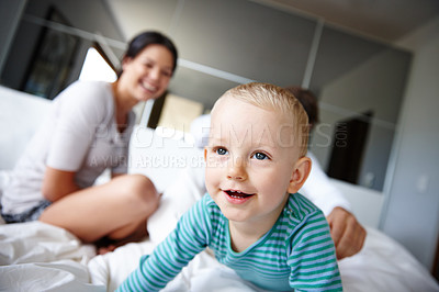 Buy stock photo Boy, child and relax on bed in home, happy and comfortable in bedroom with parents for resting. Male person, kid and wellness on weekend for waking up, childcare and care in childhood on blanket
