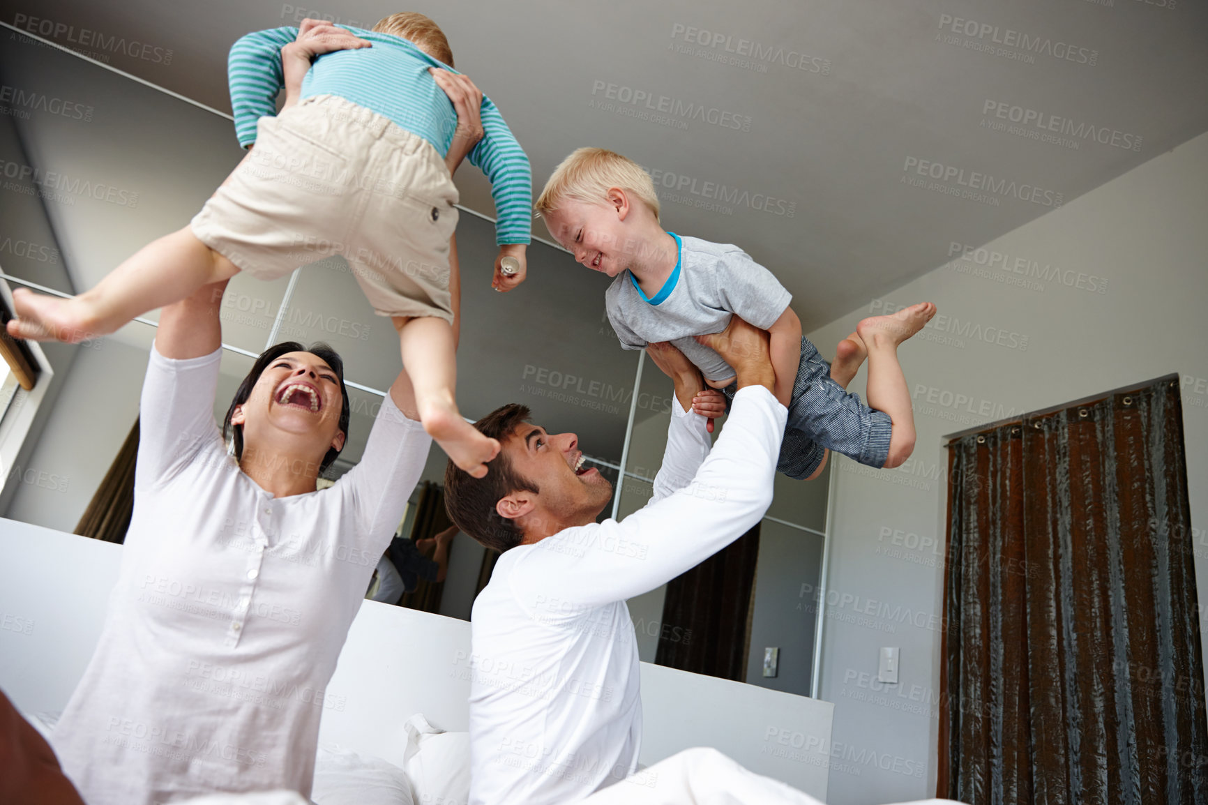 Buy stock photo Family, parents and kids in air for games, playful and fun at home for bonding, love and care with comedy. Excited, happiness and playing, people laughing together and care free energy for airplane