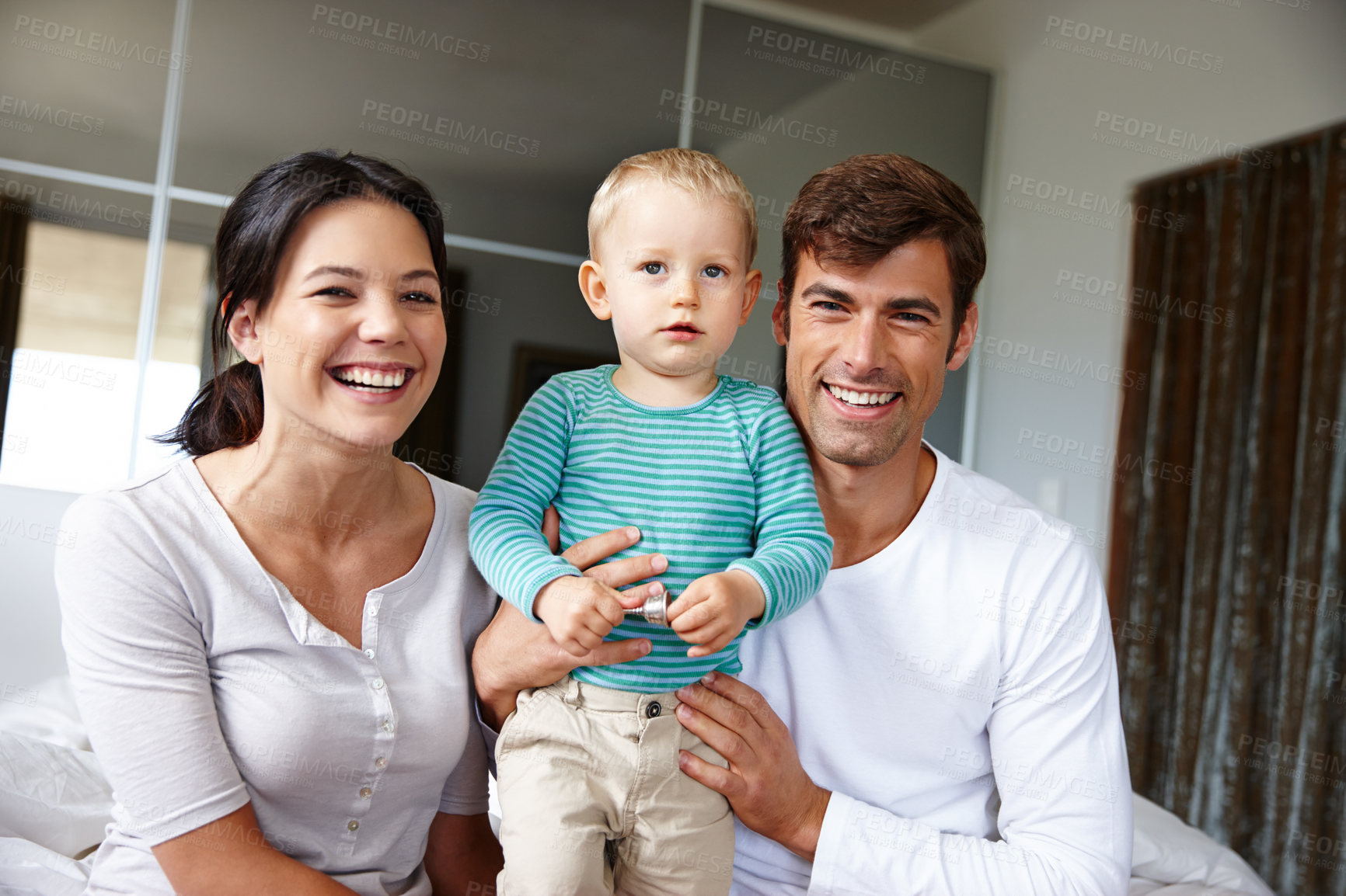 Buy stock photo Family, portrait and happy parents with child at home, love and security with parenting, childhood and bonding. Support, trust and care with man, woman and young boy in bedroom, smile and positivity