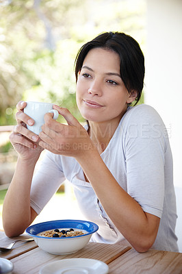 Buy stock photo Cropped shot of an attractive young woman sitting outside while having her breakfast 