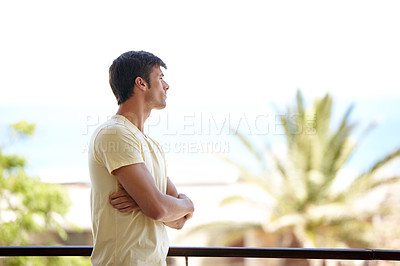 Buy stock photo A lonely man standing on holiday standing on a balcony and looking at the view at a summer vacation resort. A frustrated male feeling sad and depressed while looking thoughtful and serious at a hotel