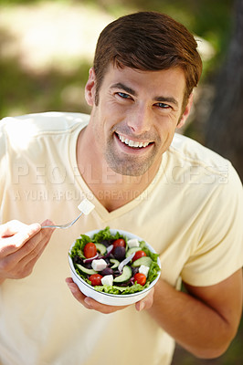 Buy stock photo Portrait male vegetarian eating a bowl of vegetables while enjoying fresh air outside, living healthy balanced lifestyle .Above view of happy man eating a healthy green salad outdoors with copyspace