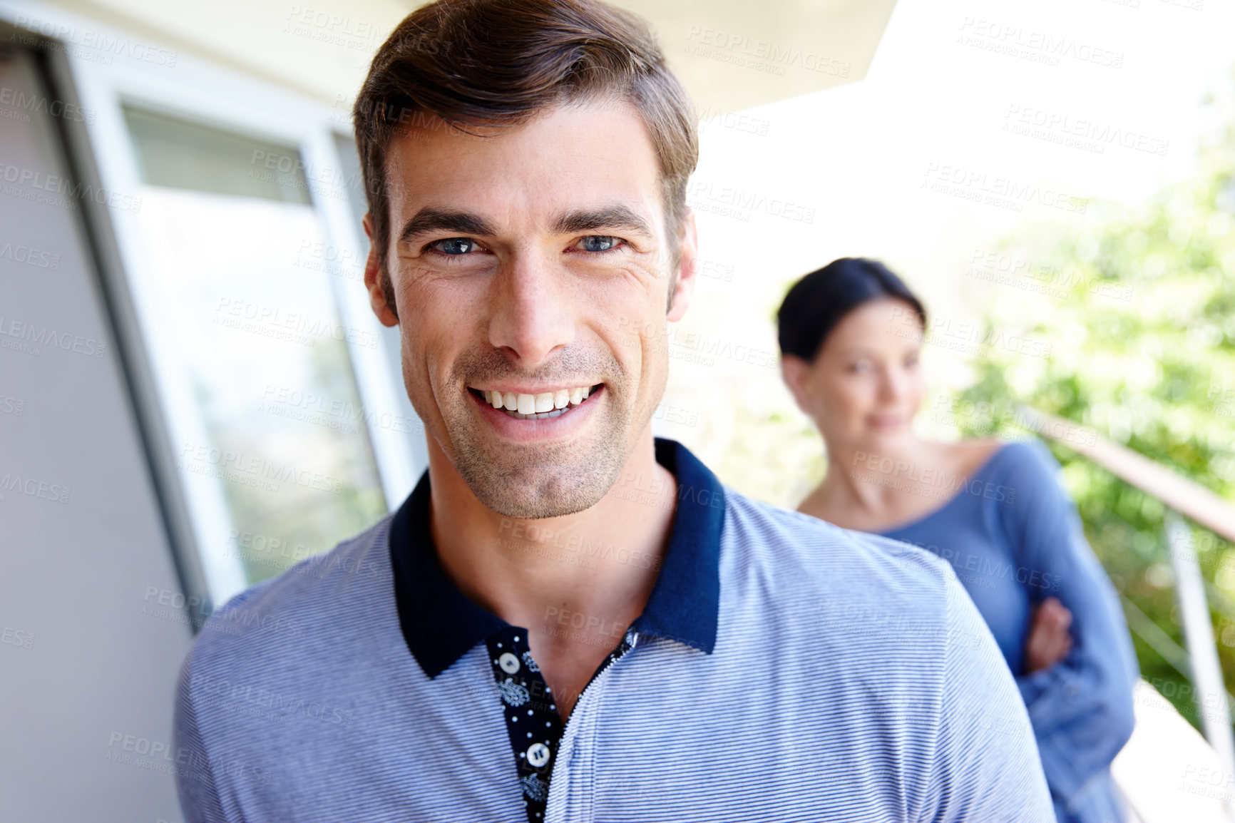 Buy stock photo Cropped shot of an attractive man and woman standing outdoors on a balcony 
