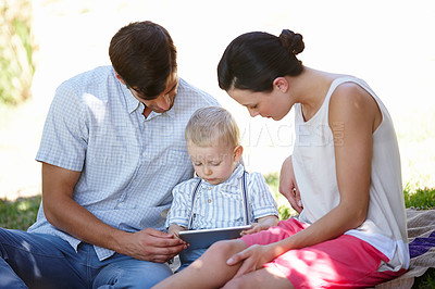 Buy stock photo Parents, child and tablet for growth, development and education with e learning in garden. Man, woman and boy on technology, educational gaming and online for motor skills, bonding and togetherness