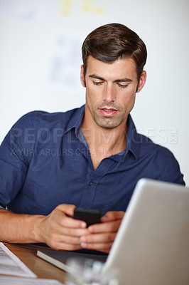 Buy stock photo Businessman, office and typing on smartphone with laptop at desk for communication, planning and information for project. Professional, person and working on computer for finance report on company