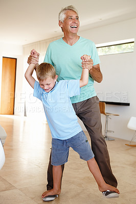 Buy stock photo Shot of a young boy walking on his grandfather's feet